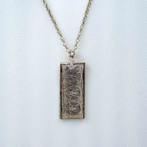 Small vertical rectangular sterling silver pendat with the impresison of 3 small sand dollars on it, with a sterling silver chain