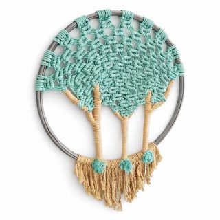 A handcrafted macramé wall hanging featuring three beige cotton palm trees with turquoise tops, woven onto a circular silver-grey hoop. The left side displays an intricate turquoise net pattern, while the right side shows fringed beige fibers forming the palm fronds. The piece rests against a clean white background, highlighting its texture and coastal-inspired design.