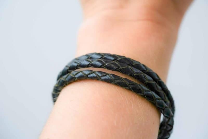 A black braided leather bracelet with brass wire wraps and a hook clasp by Oswaldo Paz local Fremantle Artisan