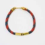 red and blue woven leather bracelet (2) Leather Woven Jewellery. A red and navy blue braided leather bracelet with antique brass fittings and a hook clasp. Hand made by Western Australian Artisan Oswaldo Paz