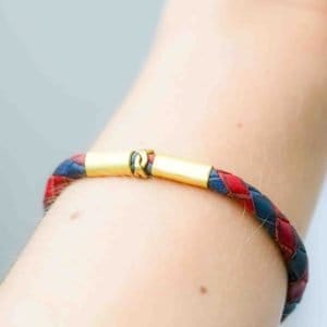 Oswaldo Paz. Western Australian Artist. Leather Woven Jewellery. A red and navy blue braided leather bracelet with antique brass fittings and a hook clasp.