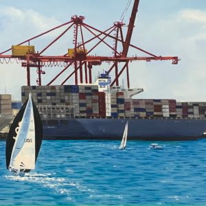 Sail boats race through the calm blue waters of the Fremantle Harbour. In the background ships sit filled with multicolour stacks of shipping containers. In the distance the traffi bridge can be seen.