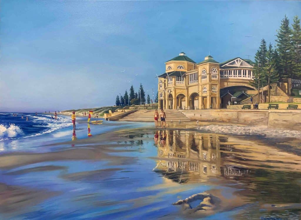 An oil painting of the historic Indiana Tea House at Cottesloe Beach, showcasing its tan, domed architecture reflected perfectly in the wet, shimmering sand at the shore's edge while beachgoers and lifesavers stroll nearby.