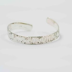 A sterling Silver bangle sits on a white background. The bangle is open, with the two ends spiral slightly upwards