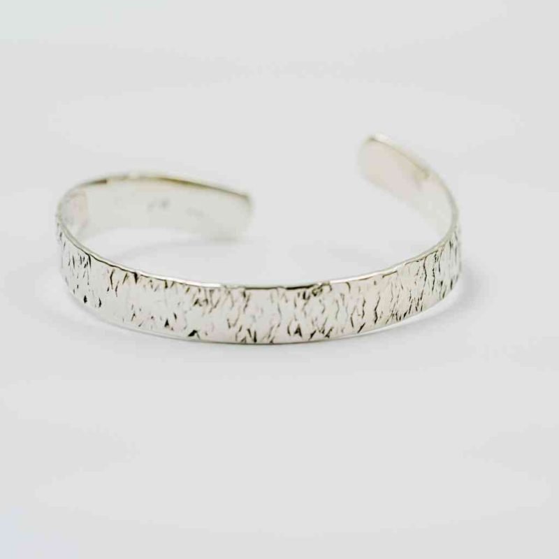 Sterling Silver Men's Adjustable cuff (1) A sterling Silver bangle sits on a white background. The bangle is open, with the two ends spiral slightly upwards