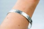 Sterling Silver Men's Adjustable cuff (2) The bangle is worn on the wrist of a fair-skinned person.