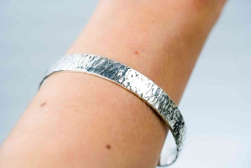 The bangle is worn on the wrist of a fair-skinned person.