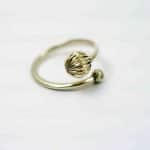 adjustable ring with two beads Fred Kuenzel (3) A silver ring in an open design, the ring is adjustable with asilver decorative ball on either end.