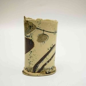 A stoneware vase made from cream-coloured clay and decorated with an array for brown an stone coloured houes. The vase sits on a white background