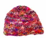 Knitted silk yarn red multicolour beanie (2) An image of a multicoloured, red-based, knitted beanie laying on a white surface