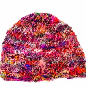 An image of a multicoloured, red-based, knitted beanie laying on a white surface