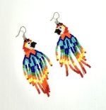 A pair of handmade beaded parrot earrings featuring vibrant colours of red, yellow, green, blue, and black. Each earring is crafted from tiny glass beads forming a detailed parrot shape with long, fringed tail feathers. The earrings hang from sterling silver hooks and are displayed against a neutral background to highlight their intricate design and bright tropical palette.