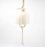 A handcrafted ceramic hanging bell with a smooth, matte ivory finish, suspended by a braided jute rope. The bell has a rounded dome shape, and a long hanging cord beneath it ending in two small matching white ceramic beads, set against a plain white background.
