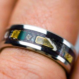 A stainless silver ring inlayed with brown resin and micro-electronics.